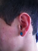 Sophomore Blake Croft displays his turquoise plugs. Croft's piercings are sized at 2g, or 1/4 inches.