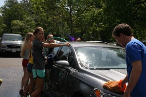 Student Gov members scrub hard to clean a teachers car