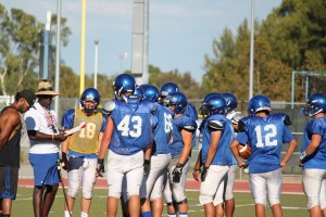 Football players huddle at practice, where they have been preparing for their televised game against Yuba City on Aug 30.