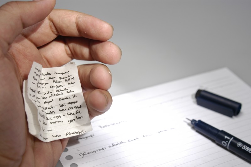 A student sneaks in a small note card to a test, easily hidden within their palm. The Josephson Institute of Ethics estimates more than one in every two students has cheated before. Courtesy photo illustration by Hariadhi/Wikimedia Commons. 