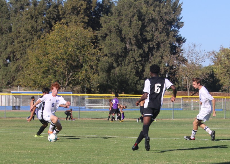 Freshman Aaron Mayr steals the ball away from a Franklin High School offender during the second half of the men’s varsity soccer match on Wednesday, Sept. 23. The Blue Devils lost to the Wildcats 3-1. 