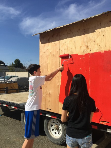 Sophomores Grayson McKim and Jun Kim help paint float along with other volunteers