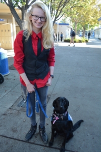 Junior Skye McIlraith poses with her service dog Olive.