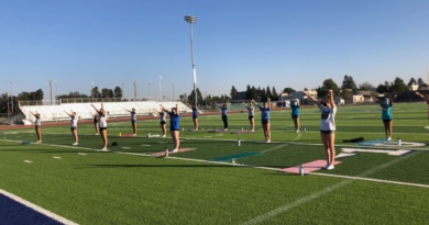 Past competitive cheerleaders practice together on the Davis High field before tryouts