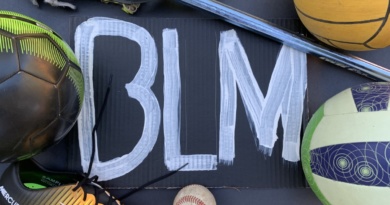Sports equipment surround the white paint reading "BLM" on the black background