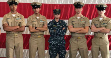 Charlotte Bowler wearing her Coast Guard damage controlman uniform with two cadets on either side