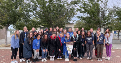 The Davis High women's swim team poses with their 2022 championship banner.