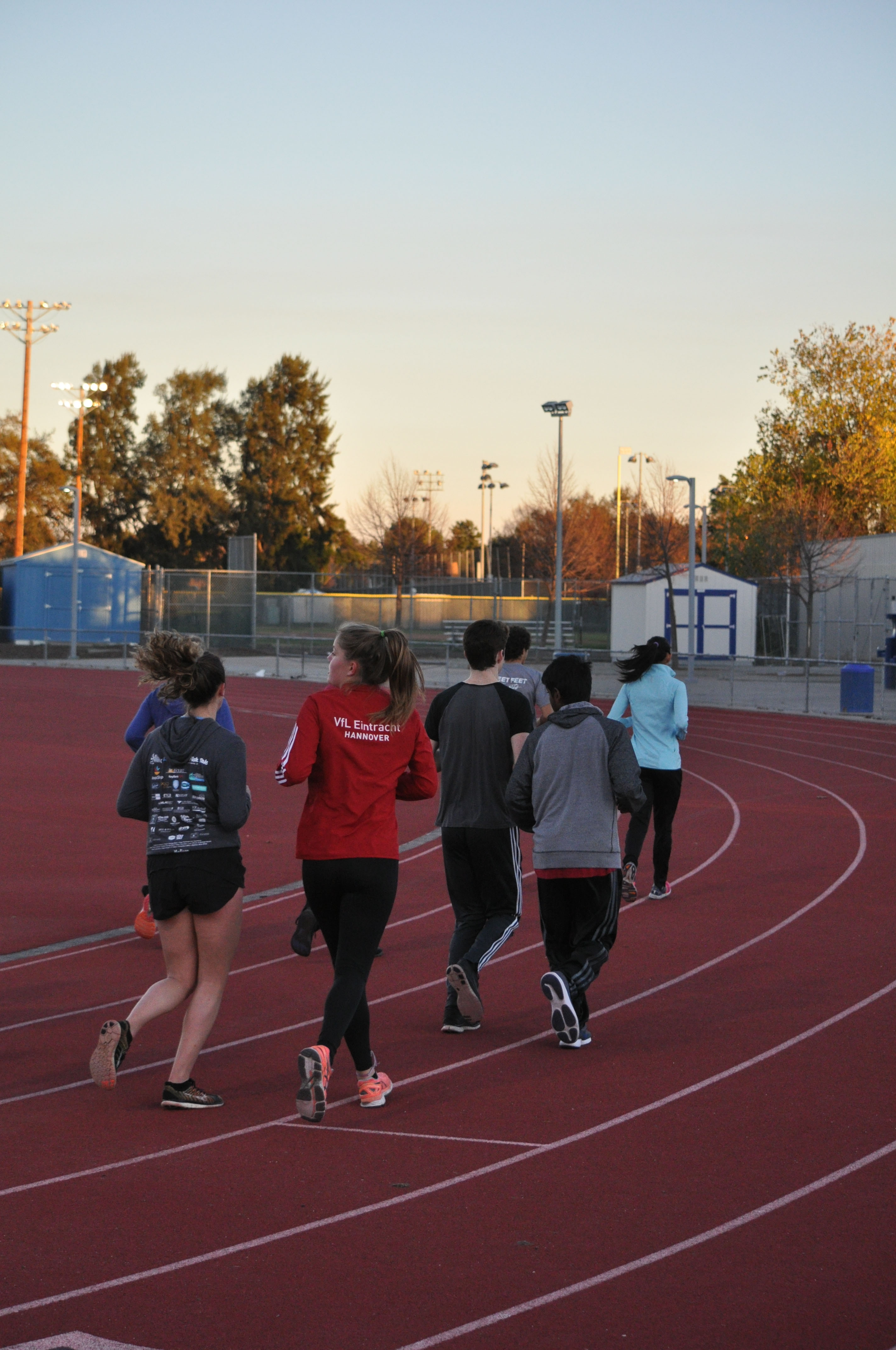 A group of runners begins a lap around the track.
