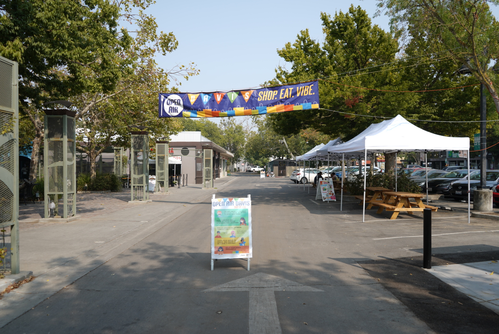 A sign stands under a banner signifying the "open-air" part of downtown Davis.