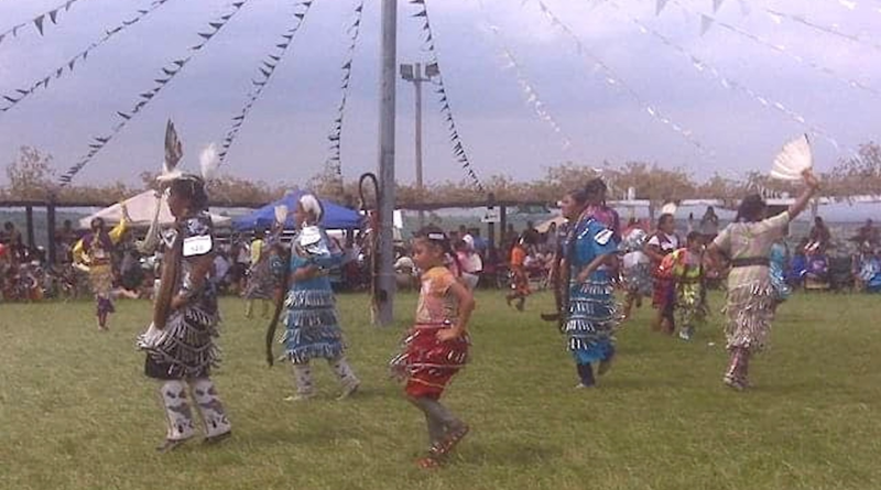 A Native American tribe celebrating indigenous cultures by dancing