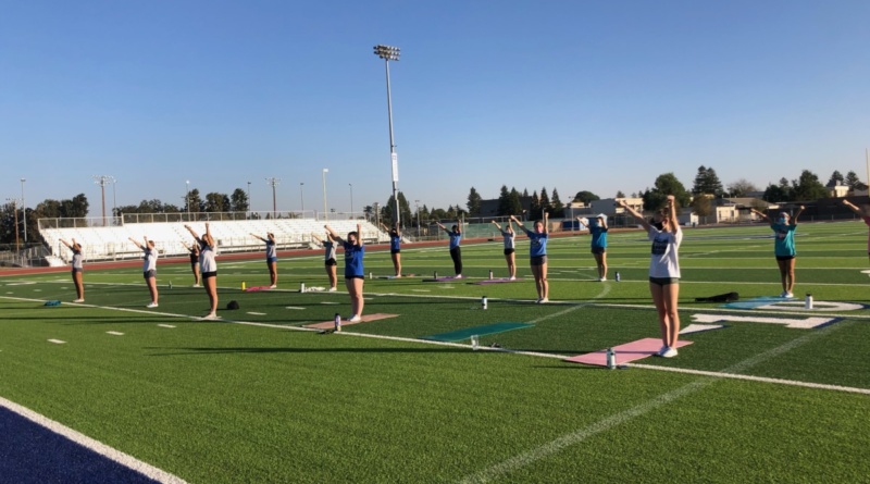 Past competitive cheerleaders practice together on the Davis High field before tryouts