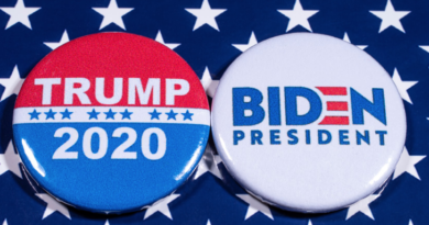 Two buttons reading "Trump 2020" and "Biden president" displayed on top a blue tablecloth with white stars