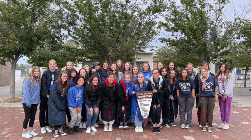 The Davis High women's swim team poses with their 2022 championship banner.